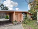 Inviting home entrance with covered parking, an outdoor bench, and tropical greenery at 602 Bonito Ave, Nokomis, FL 34275