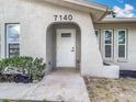 Close-up of the front door with modern hardware and landscaping at 7140 Teaberry St, Englewood, FL 34224