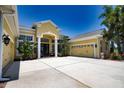 Attractive yellow single-story home featuring a spacious driveway, two-car garage, and lush greenery at 8209 Snowy Egret Pl, Bradenton, FL 34202