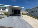 A single-story home with a covered parking area and a well-maintained lawn at 834 Cervina S Dr, Venice, FL 34285