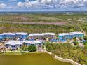 Wide aerial shot of condo community by a pond, showing lush landscaping and colorful residential buildings at 8409 Placida Rd # 206, Placida, FL 33946