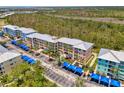 Aerial view showcasing a condo complex with vibrant buildings, covered parking, and palm-lined parking areas at 8409 Placida Rd # 206, Placida, FL 33946