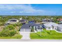 An aerial view showcasing a modern home with a three-car garage and canal access at 8634 Santa Cruz Dr, Port Charlotte, FL 33981