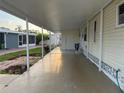 Spacious covered carport of a manufactured home with an extended driveway and outdoor storage at 868 Baveno Dr, Venice, FL 34285