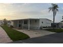 Well-maintained manufactured home with a covered carport and neat landscaping for curb appeal at 868 Baveno Dr, Venice, FL 34285