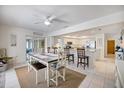 Open dining area flowing into the kitchen, featuring neutral decor, an eat-in bar, and tile flooring throughout at 9277 Saint Catherine Ave, Englewood, FL 34224