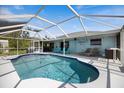 Inviting screened-in pool area with lounge chairs, dining set, ceiling fan, and a clear blue swimming pool at 9277 Saint Catherine Ave, Englewood, FL 34224