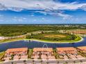 Aerial view of the townhouses within a Primary planned community that feature water views and mature landscaping at 10213 Staggerbush Dr # 202, Venice, FL 34293