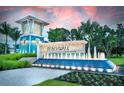 Beachwalk community entrance with a water feature, guardhouse, and tropical landscaping at 10367 Abaco Falls Dr, Englewood, FL 34223