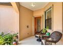 Inviting front porch with potted plants and wicker furniture at 11103 Batello Dr, Venice, FL 34292