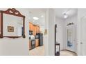 Open hallway view to kitchen and front door featuring neutral color scheme at 11103 Batello Dr, Venice, FL 34292