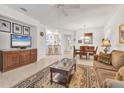 Bright living room with tile flooring, ceiling fan, and open layout to dining area at 11103 Batello Dr, Venice, FL 34292