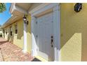 Classic white front door with sidelight and exterior light fixture at 11624 Garessio Ln, Sarasota, FL 34238