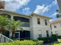Two story condominium building featuring well-maintained landscaping, white trim, and a private balcony at 1204 L Pavia Blvd # 1204, Venice, FL 34292