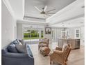 Open-concept living room with wicker seating, a blue sofa, recessed lighting and patio access at 1228 Pineland Ave, Venice, FL 34285