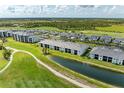 Scenic aerial view of condos with community lake and golf course views at 12390 Wellen Golf St # 203, Venice, FL 34293