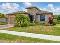 Charming single-story home showcasing lush landscaping and manicured lawn at 12871 Cinqueterre Dr, Venice, FL 34293