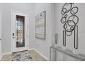 Elegant foyer features a decorative glass door and contemporary artwork at 12871 Cinqueterre Dr, Venice, FL 34293