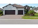 Charming home exterior with a three-car garage and well-maintained landscaping in a sunny setting at 13056 Steinhatchee Loop, Venice, FL 34293