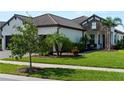 Charming home featuring stone accents, lush landscaping, and a well-manicured lawn at 13056 Steinhatchee Loop, Venice, FL 34293