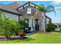 Inviting front entrance with stone accents, beautiful landscaping, and a cozy seating area at 13056 Steinhatchee Loop, Venice, FL 34293