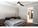 This cozy bedroom features a plush bed, a ceiling fan, and an ensuite bathroom at 136 Positano Trl, Nokomis, FL 34275