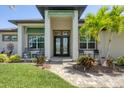 Inviting home entrance with decorative double doors, manicured landscaping, and a charming brick pathway at 14398 Fort Worth Cir, Port Charlotte, FL 33981