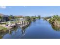 Picturesque waterfront view showcasing a private boat dock, calm waters, and lush tropical landscaping at 14398 Fort Worth Cir, Port Charlotte, FL 33981