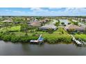 Aerial view of a luxurious waterfront home with a private dock and serene lake views at 15336 Spanish Point Dr, Port Charlotte, FL 33981