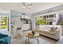 Cozy living room featuring a couch, integrated kitchen, and natural light streaming through large windows at 1555 Tarpon Center Dr # G 235, Venice, FL 34285