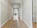 View of the light and airy hallway with hardwood floors and an eye-catching carpet, leading into the sun-filled living area at 15963 Crofton Springs Way, Port Charlotte, FL 33953