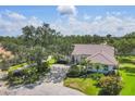 Well-manicured home featuring a tile roof, lovely landscaping, and a circular driveway at 188 Grand Oak Cir, Venice, FL 34292