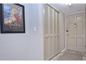 Hallway shot featuring a closet with bi-fold doors, a front door, neutral paint, and art at 200 The Esplanade N # C19, Venice, FL 34285