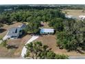 Aerial view of a home and its surroundings, including a white gravel driveway and mature tree coverage at 2008 55Th E Ave, Bradenton, FL 34203