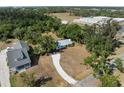 Aerial view of a home and its surrounding lot, next to wooded area, a driveway, and neighboring homes at 2008 55Th E Ave, Bradenton, FL 34203
