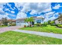 Inviting one-story home featuring a three-car garage, nicely landscaped yard, and charming curb appeal at 20235 Granlago Dr, Venice, FL 34293