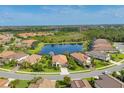 A picturesque aerial view of a residential area highlighting a central pond and manicured landscaping at 213 Malina Ct, Nokomis, FL 34275