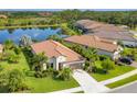 Aerial view showcasing a home near a serene pond, accented by lush landscaping and palm trees at 213 Malina Ct, Nokomis, FL 34275
