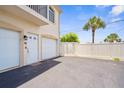 An inviting exterior of a residence with white doors, a paved parking area, and a well-maintained yard at 235 Base E Ave # 207, Venice, FL 34285