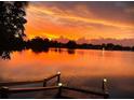 Scenic lake view with a wooden dock, reflecting the vibrant colors of the sunset sky at 249 Hallcrest Ter, Port Charlotte, FL 33954