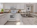 Bright kitchen featuring an oven and microwave combo, neutral countertops and white cabinets at 25050 Sandhill Blvd # 6A3, Punta Gorda, FL 33983