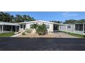 Front exterior view of cozy home featuring an attached carport and tidy landscaping at 310 Tropic Dr, Osprey, FL 34229