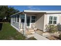 Home exterior featuring an enclosed porch, easy access ramp, and manicured landscaping at 310 Tropic Dr, Osprey, FL 34229