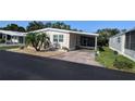 Exterior of home showing carport, stone landscaping, and well-maintained lawn at 310 Tropic Dr, Osprey, FL 34229