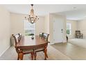 Dining room with a wood table, chandelier, and natural light through the windows at 4890 Laramie Cir, North Port, FL 34286