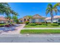 Well-manicured lawn and lush landscaping enhance this home's curb appeal, offering a welcoming view at 5018 Bella Terra Dr, Venice, FL 34293