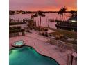 Community pool and waterfront in the evening featuring chairs and sunset views at 516 Tamiami S Trl # 303, Nokomis, FL 34275