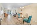 Open-concept living room with a glass dining table and plenty of natural light at 708 Tamiami S Trl # 115, Venice, FL 34285