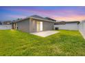 Spacious backyard with a well-maintained lawn and a cozy patio area, enclosed by a white fence at 711 Brenton Leaf Dr, Ruskin, FL 33570