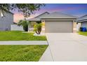 Beautiful home with lush green lawn, well-kept landscaping, and a large driveway leading to a garage at 711 Brenton Leaf Dr, Ruskin, FL 33570